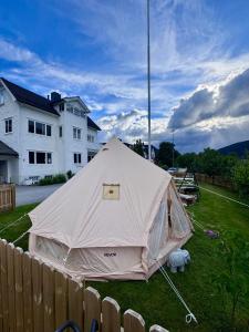 a tent in a yard in front of a house at Rampestreken Glamping in Åndalsnes