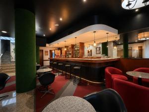 a restaurant with a bar with chairs and tables at Curitiba Palace Hotel in Curitiba +42 photos