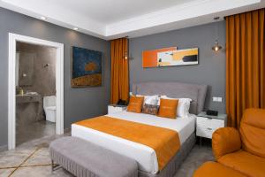 a bedroom with a large bed and a chair at The Alima Suites in Accra +36 photos