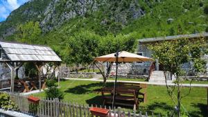 a garden with a picnic table and an umbrella at Stomici Guesthouse in Ndërlysaj +46 photos