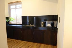 a kitchen with a black counter top and a sink at Bunk 7 in Kandy +11 photos