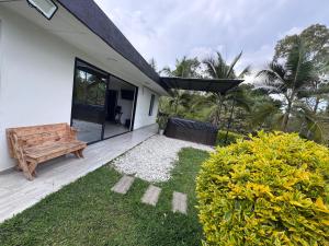 a house with a wooden bench and a garden at Lisboa Hause in Horizonte