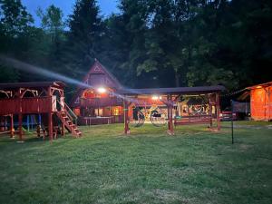 a barn with lights in the yard at night at Cabana Paltini in Costeşti