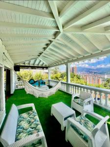 a porch with chairs and hammocks on a balcony at The Butterfly Mansion in Envigado