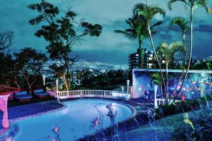 a swimming pool with a view of the city at night at The Butterfly Mansion in Envigado