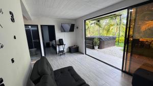 a living room with a couch and a sliding glass door at Lisboa Hause in Horizonte
