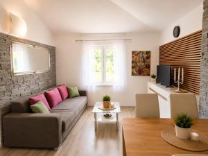 a living room with a gray couch and pink pillows at Adriatic Star in Banjol