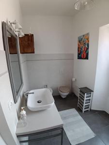 a white bathroom with a sink and a toilet at La Corte della Musica in Roppolo