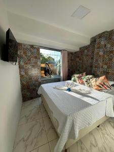 a bedroom with a large bed with a window at Pousada e Restaurante Morena Raiz in Olinda