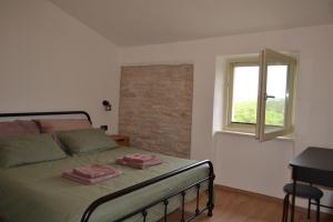 a bedroom with a bed with two towels on it at Casa Evelina in Čepić