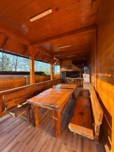 a dining room with a wooden table and benches at Violetta Cottage in Užice +48 photos
