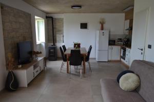 a kitchen and living room with a table and chairs at Casa Evelina in Čepić
