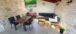 a patio with a table and chairs and a couch at Casa Evelina in Čepić