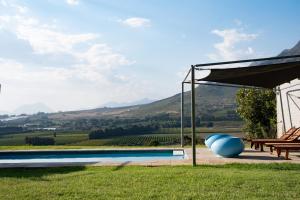 a swimming pool with a view of a vineyard at Big Sky Cottages in Wolseley
