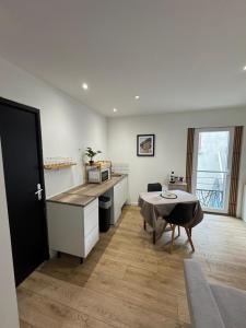 a kitchen with a table and a dining room at Les Perles de Limoux - Centre Clim Wifi Parking Gratuit in Limoux