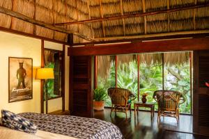 a bedroom with a bed and a table and chairs at Blancaneaux Lodge by Francis Ford Coppola in Blancaneau +102 photos
