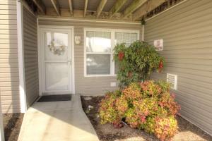 a front door of a house with a flower bush at 30399 Pavilion Dr, #1301, Ocean View in Ocean View