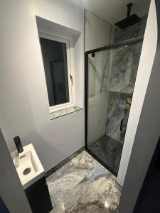 a bathroom with a shower and a sink at The Hideaway Aylesbury in Buckinghamshire