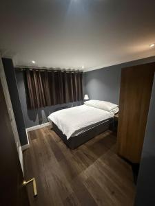 a bedroom with a large bed and a window at The Hideaway Aylesbury in Buckinghamshire