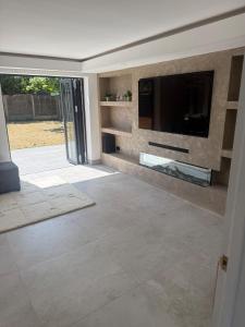 a living room with a flat screen tv on a wall at The Hideaway Aylesbury in Buckinghamshire