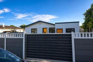 a house with a black gate and a white fence at 60 On Kosmos in Bellville South