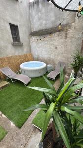 a backyard with a hot tub and a grass yard at Les Perles de Limoux - Centre Clim Wifi Parking Gratuit in Limoux
