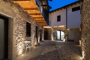 an alleyway between two buildings with a table and chairs at Antica corte in Zogno