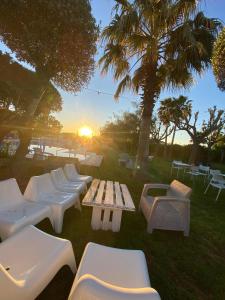 a group of white benches and a table with the sunset at Hostal Al-Andalus in La Guijarrosa
