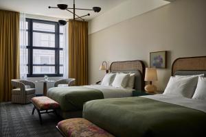 a hotel room with two beds and a window at Cincinnati's Fidelity Hotel in Cincinnati