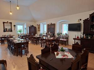 a dining room with tables and chairs and a television at Hostinec u Janatů s ubytováním in Čestín