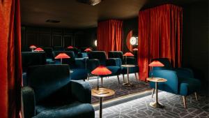 ein Wartezimmer mit blauen Stühlen und roten Vorhängen in der Unterkunft Ruby Mimi Hotel Zurich by IHG in Zürich