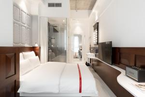 a bedroom with a large white bed and a television at Ruby Louise Hotel Frankfurt by IHG in Frankfurt +84 photos