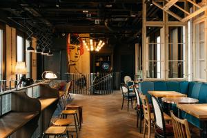 a bar with tables and chairs in a restaurant at Ruby Louise Hotel Frankfurt by IHG in Frankfurt