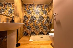 a bathroom with a sink and a toilet with a wallpaper at B&B Belvedere in Colico +56 photos