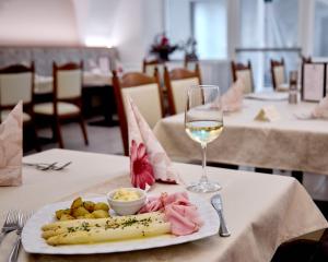a plate of food and a glass of wine on a table at Hotel Markushof - Adults only in Auer