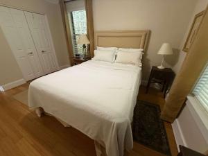 a bedroom with a large bed with white sheets and pillows at Stone Cottage 1973 in Lake Junaluska