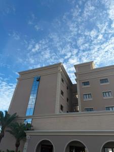 a large building with a blue sky in the background at Class Hotel Americana in Americana