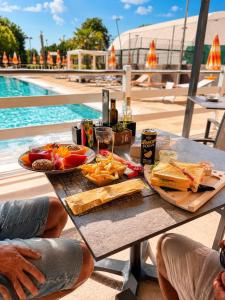 a picnic table with food and drinks next to a pool at Ancora Sport Resort Hotel in Meolo