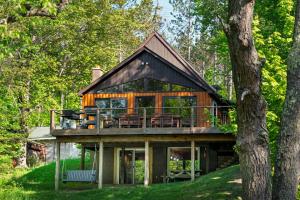a house with a wrap around deck in the woods at Crystal Cabin on the Betsie in Thompsonville