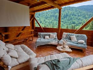 a living room with couches and a table in a cabin at Cabana KayLuna in Mătişeşti +84 photos