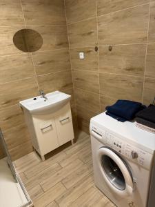 a bathroom with a washing machine and a sink at Stodolni centre LOFT in Slezská Ostrava