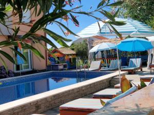 a swimming pool with lounge chairs and umbrellas next to at Adriatic Star in Banjol