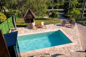 a swimming pool with chairs and a gazebo at Kosmaj Apartmani Košutica - Marija i Ksenija in Koraćica
