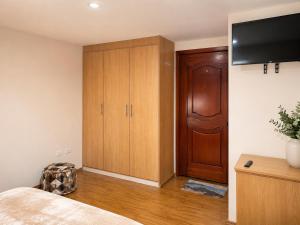 a bedroom with a bed and a wooden cabinet at Comfortable with Private Garage and Excellent Location Rb in Riobamba