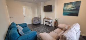 a living room with a blue couch and a tv at Flat 21 - 1st floor - Westview Terrace, Stornoway in Stornoway
