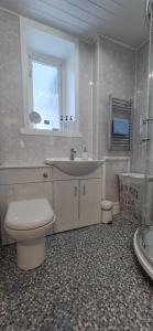 a bathroom with a toilet and a sink and a tub at Flat 21 - 1st floor - Westview Terrace, Stornoway in Stornoway +12 photos
