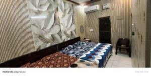 a bedroom with a bed and a chair in a room at Maa janki paying guest house near Ram mandir in Ayodhya