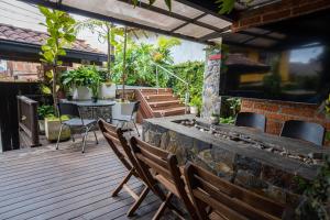 a patio with a table and chairs on a wooden deck at Hotel Alto lindo in Guatapé
