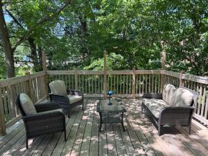 a deck with chairs and a couch and a table at Manville Heights Modern in Iowa City