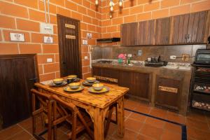 a kitchen with a wooden table with dishes on it at Hotel Alto lindo in Guatapé